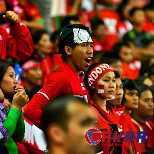 Suporter Indonesia memberi dukungan dalam pertandingan internasional sepak bola.