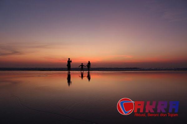 Siluet keluarga di pantai saat senja untuk ilustrasi libur keluarga sekitar Medan